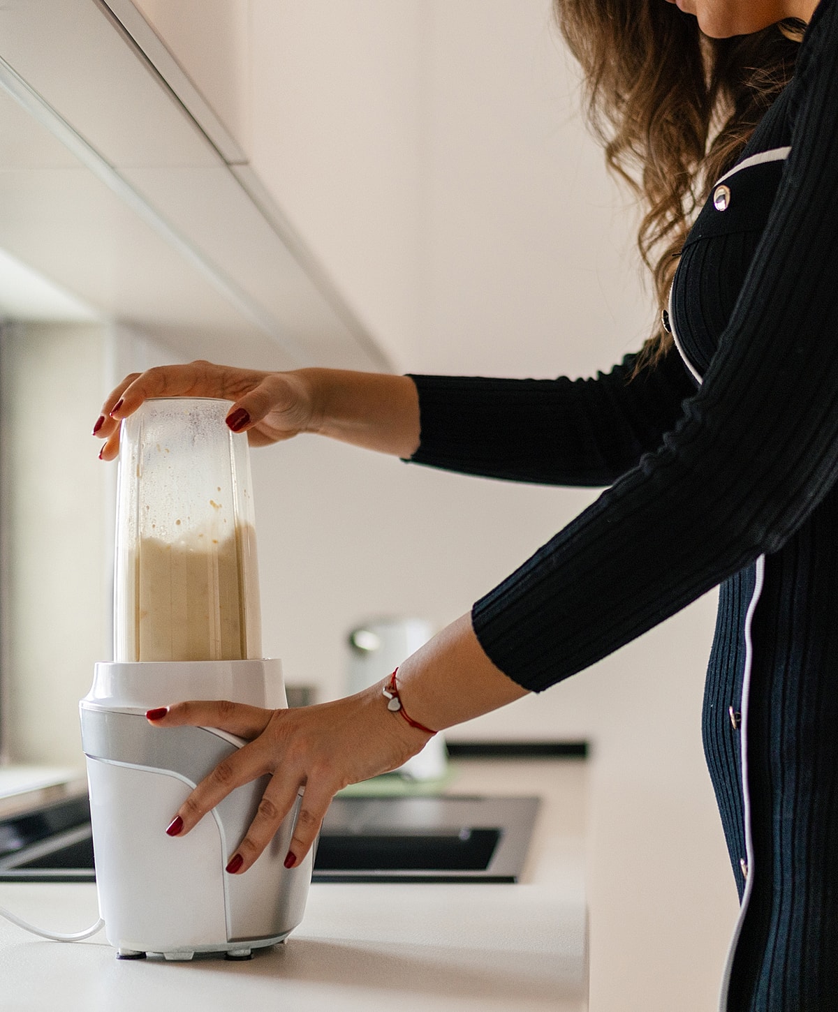 Woman using a blender in a kitchen.